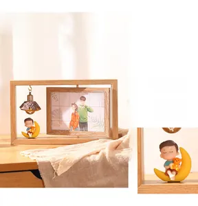 Detail of 360-degree rotating wood photo frame with moon boy figure and home hanging lamp