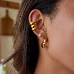 Dettaglio di orecchini a cerchio placcati oro 18K con motivo a stelle e piccoli diamanti su modella