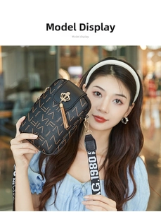 Detailed view of black leather phone bag with VIF print and gold crown tassel charm