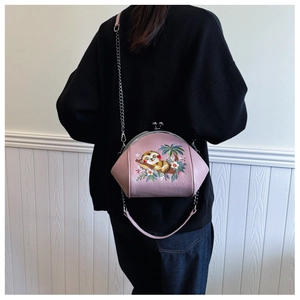 Detail of pink embroidered shell bag with sloth pattern and metal chain strap