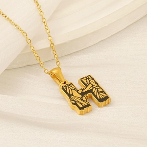 Golden H-letter pendant necklace with black enamel inlay on elegant white background