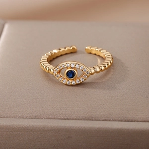 Macro detail of Evil Eye open ring with blue stone and gold beaded adjustable band