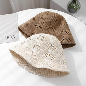 Detail of knitted sun hats with hollow diamond patterns in cream and khaki colors