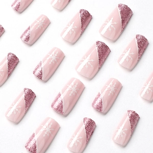 Pink press on nails with white snowflakes and glittering diagonal french tips on white background