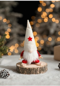 Close-up of a Christmas gnome figurine with wooden skis and faux fur beard on snow