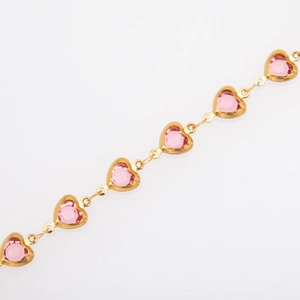 Close-up of gold-plated bracelet featuring heart-shaped charms with pink crystals