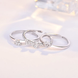 Macro shot of silver open rings with hollow heart designs and shimmering zircons