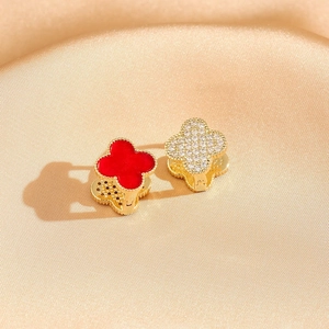 Golden clover earrings with red enamel and pavé zircon stones on champagne silk