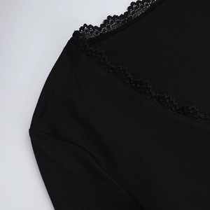 Detail shot of elegant black lace trim and textured fabric on the V-neck collar