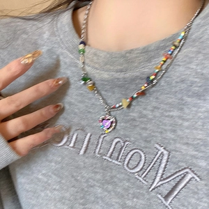 Colorful beaded heart necklace with purple pendant and silver chain on model