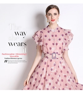 Nahaufnahme von Stehkragen und Rüschenärmeln am rosa Punktekleid mit Gürtel