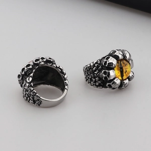 Detailed macro view showing the yellow stone and skull carvings of this punk steel ring