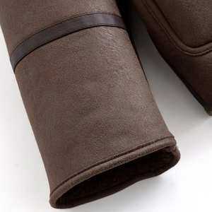Détail de la manche d'une veste en daim marron foncé avec doublure en peau de mouton