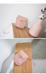 Close-up of pink crocodile texture crossbody bag with gold metallic twist lock
