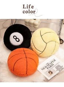 Plush sports ball pillows including basketball and volleyball on white faux fur carpet