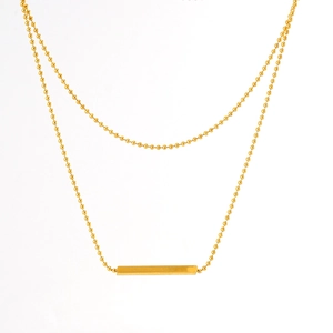 Close-up of golden double-layer T-bar necklace with rectangular pendant on white backdrop