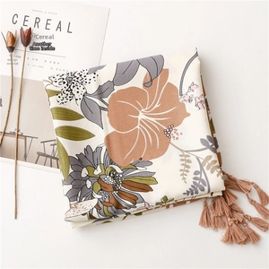 Detail of floral printed scarf with handcrafted tassels and vintage botanical patterns