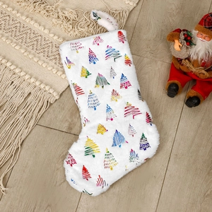 White plush Christmas stocking with colorful tree patterns on rustic wooden floor