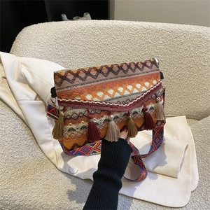Detail of bohemian tapestry crossbody bag featuring fringe tassels and woven patterns