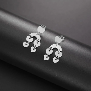 Elegant silver stainless steel dangling earrings with multiple heart charms on a dark base