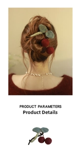 Detail of wool knit cherry hair claw clip showing textured red cherries and green leaves