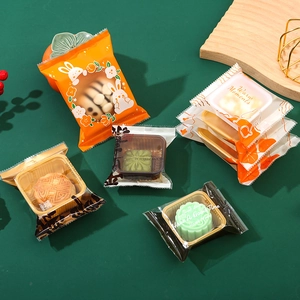 Mid-Autumn Mooncake packaging bags with Warm Moments floral design on a green table