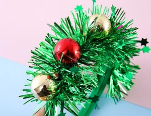 Detail of Christmas headband with sequined green stars and metallic festive balls