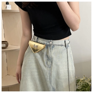 Détail du sac banane triangle doré avec papillon en cristal et chaîne argentée fine