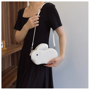 Vue détaillée d'un sac bandoulière blanc en forme de lapin avec ferrures dorées et texture cuir