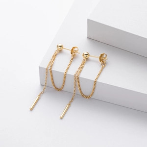 Detail view of gold S925 sterling silver long drop earrings with thin chains on white stand