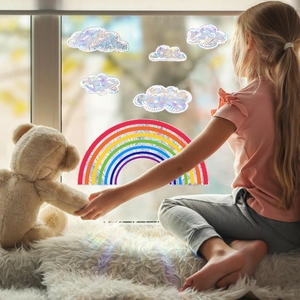 Holographic rainbow and cloud window stickers casting vibrant light onto a plush carpet