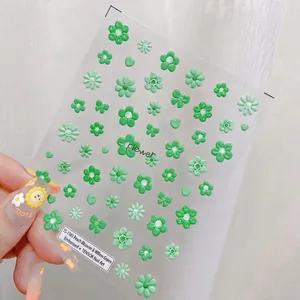 Macro detail of TS-1183 embossed 3D nail stickers with green floral and heart patterns