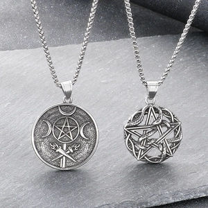 Gothic stainless steel snake and pentagram moon necklace on rustic grey stone background