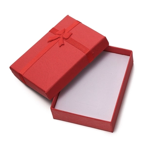 Macro view of textured red jewelry gift box with ribbon bow and white interior padding