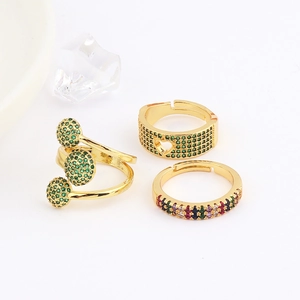 Detailed view of three gold adjustable rings with green and colorful zircon stones