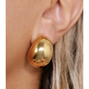 Boucles d'oreilles dôme dorées minimalistes avec finition miroir sur mannequin femme