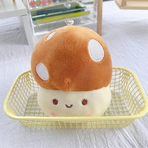 Close-up of cute mushroom plush keychain with a smiling face and orange polka dot cap