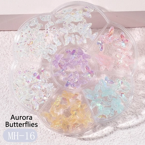 Detailed view of aurora resin butterfly nail charms in a clear hexagonal organizer box