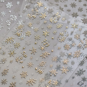 Dettaglio degli adesivi per unghie a fiocco di neve a rilievo con finitura oro e argento