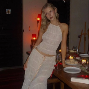 Detailed close-up of white halter neck top and pleated fabric texture for women