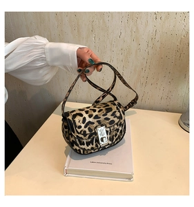 Macro view of leopard print texture and silver twist lock on the saddle crossbody bag