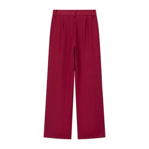 Detail of high-waisted wide-leg trousers in dark red with tailored pleats and belt loops