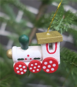 Set of 6 wooden Christmas train ornaments in red and gold hanging on a Christmas tree