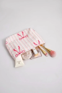 Detail view of pink striped cotton makeup bag showing spacious interior with cosmetics