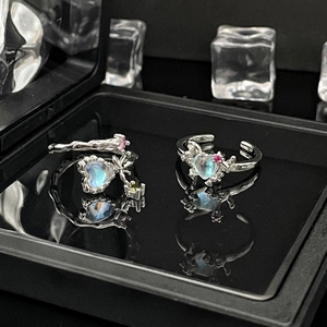 Detailed macro view of silver moonstone rings with pink gemstones on black background