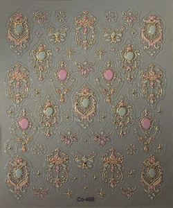 Close-up of 3D embossed baroque nail sticker with gold accents and pink gemstones