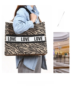 Macro shot of large jute tote bag with zebra print and LOVE ribbon detail
