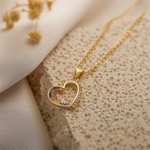 Détail du pendentif cœur plaqué or avec zircons arc-en-ciel sur pierre texturée