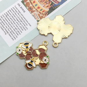 Detail view showing front and back of honeybee honeycomb enamel charms for DIY jewelry
