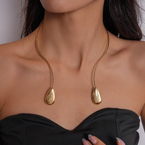 Close-up of golden minimalist open choker with polished teardrop-shaped metal pendants